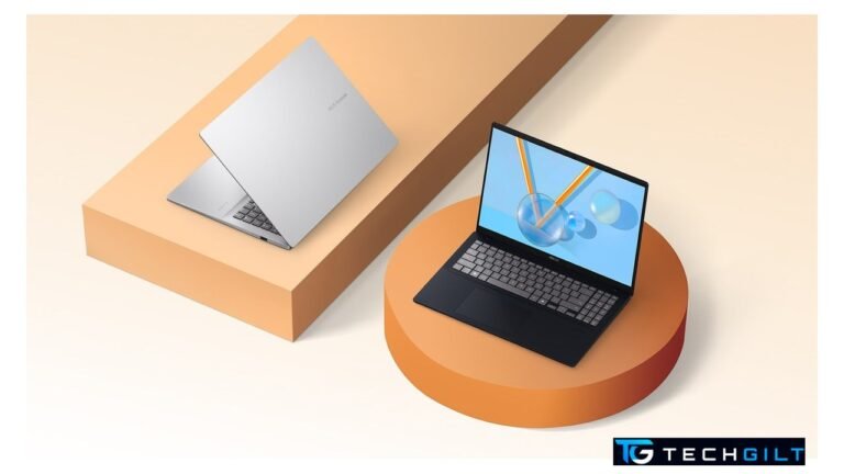 Asus Vivobook 2026 laptops, one silver and one black, on orange display stands